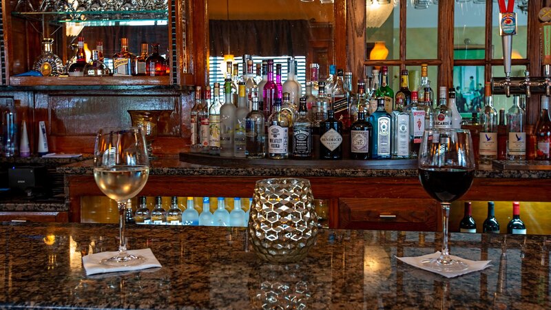 Front bar area with red and white wine glasses on bar top