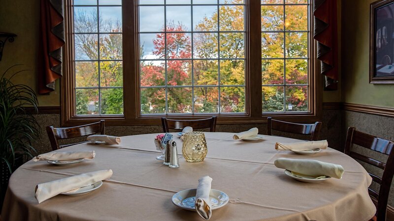 Set table with seating for eight with view of outside of restaurant