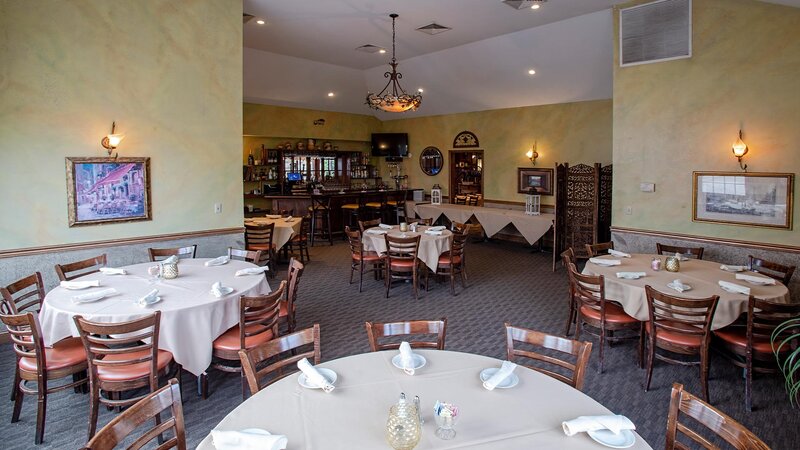 Catering room with five set tables and view of bar area